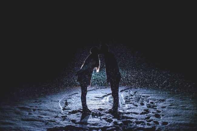 couple romantic kissing at night in the snow love