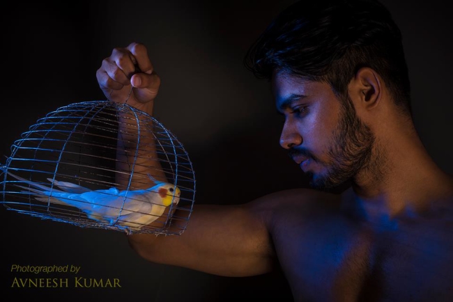 Man with bird cage. Photography by Avneesh Kumar