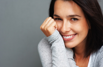 Woman brunette smiling with hands by face