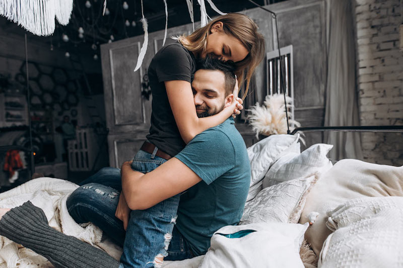 happy couple hugging in bed