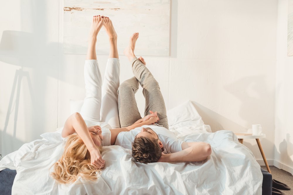 happy couple lying in bed together, love