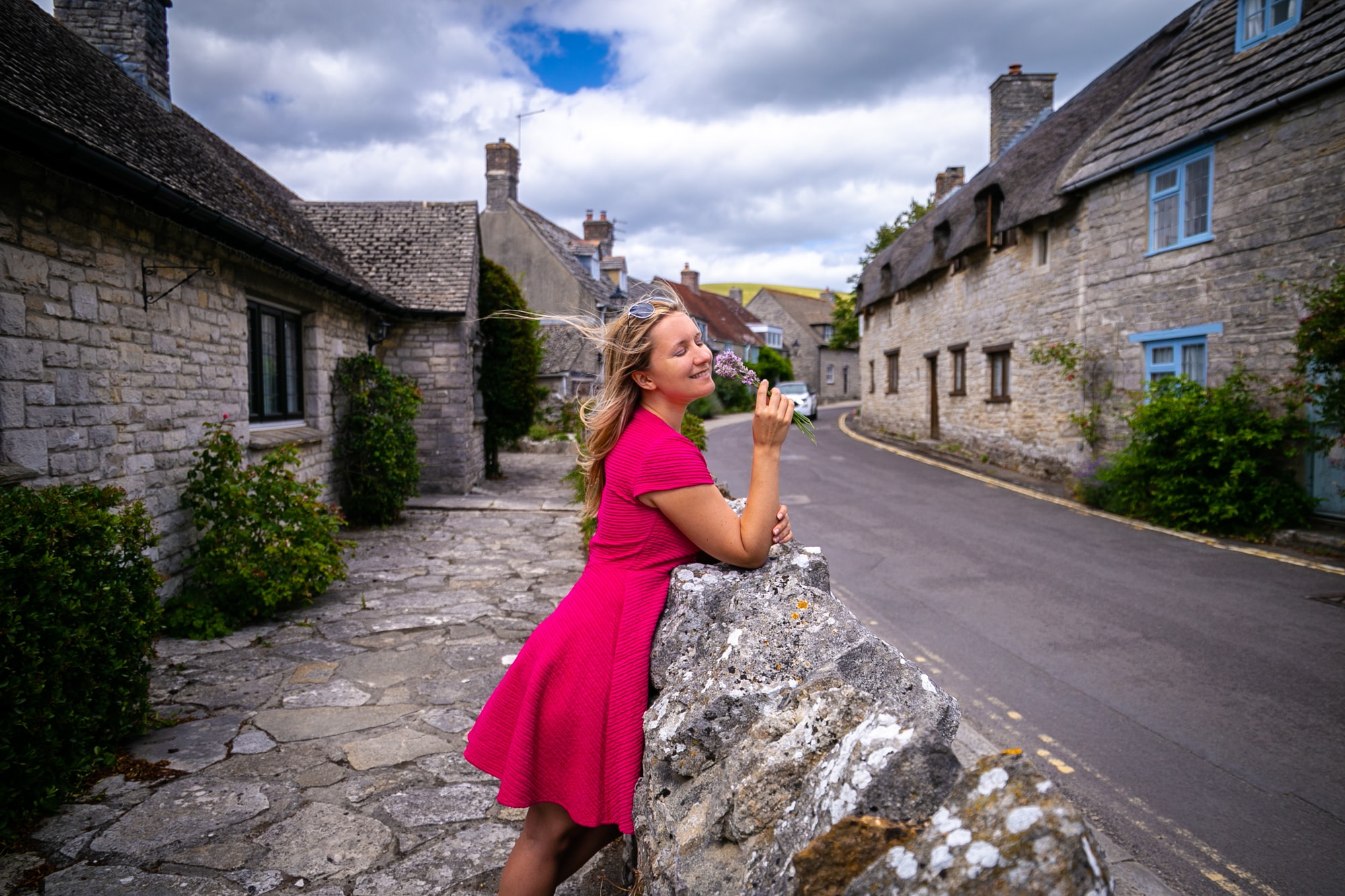 Anya Andreeva smelling lavender in British village in pink dress