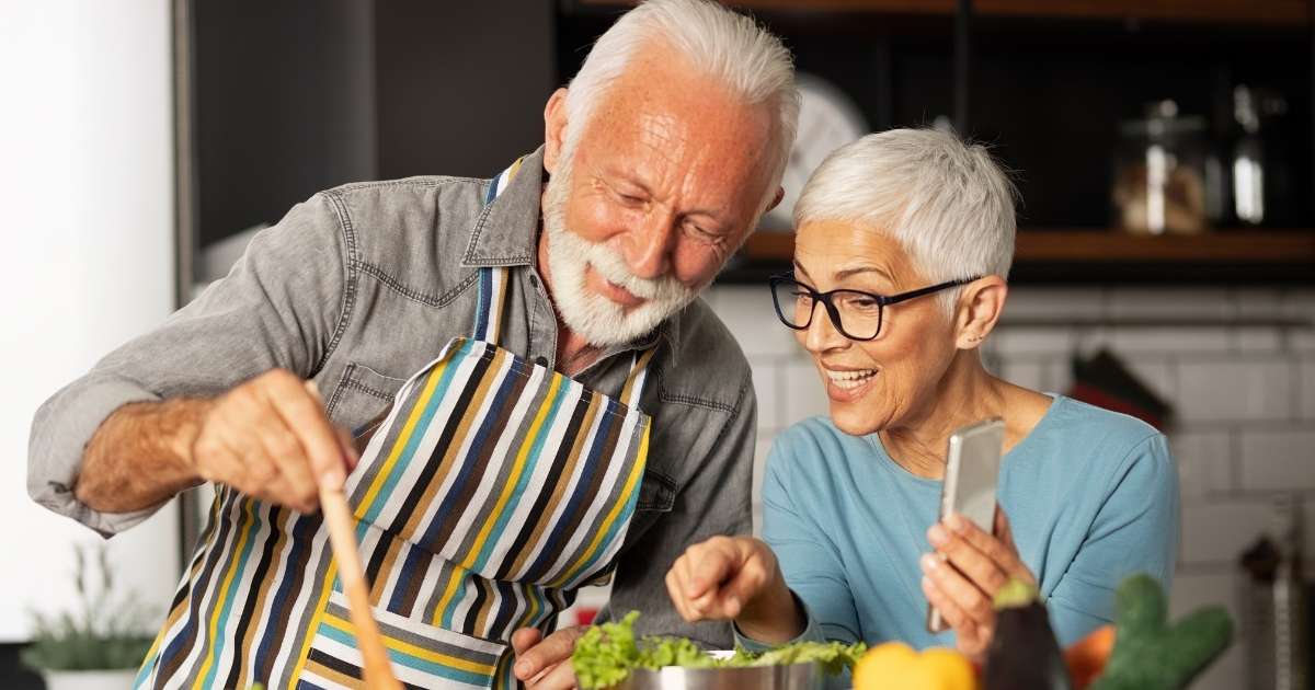 happy older couple cooking food