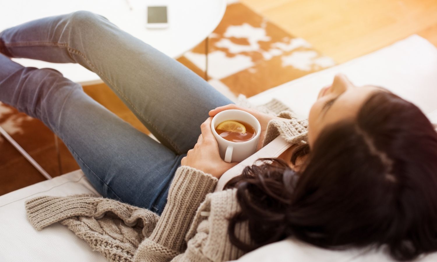 Woman relaxing at home with a cup of tea