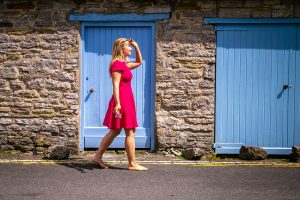 Anya Andreeva walking in pink dress by blue door